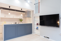 キッチンスペースと壁掛けテレビ。スッキリとしたデザイン。スキップフロアからリビング・ダイニングを見渡すことが可能。